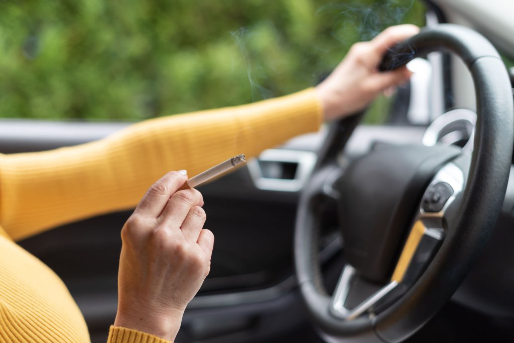 Smoking while driving, Woman smoking a cigarette while driving